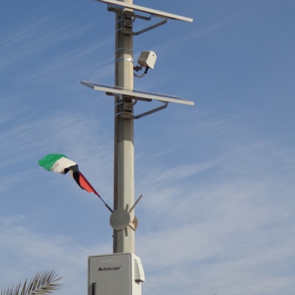 A solar panel on a pole next to a flag featured in the Main Page Template.