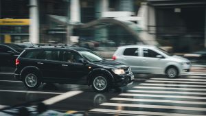 A car maneuvering through traffic on a rainy street.